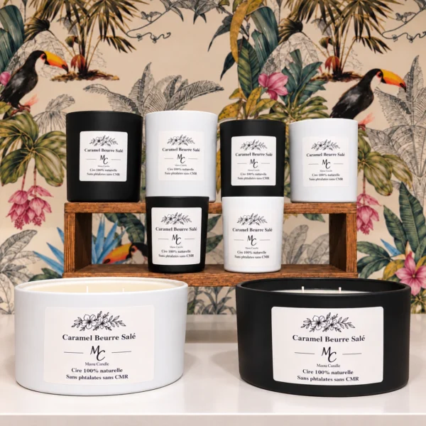 Bougie parfumée Caramel beurre salé – Maou Candle Bougies parfumées Caramel beurre salé Maou Candle en pots noirs et blancs, disposées devant un décor floral coloré.